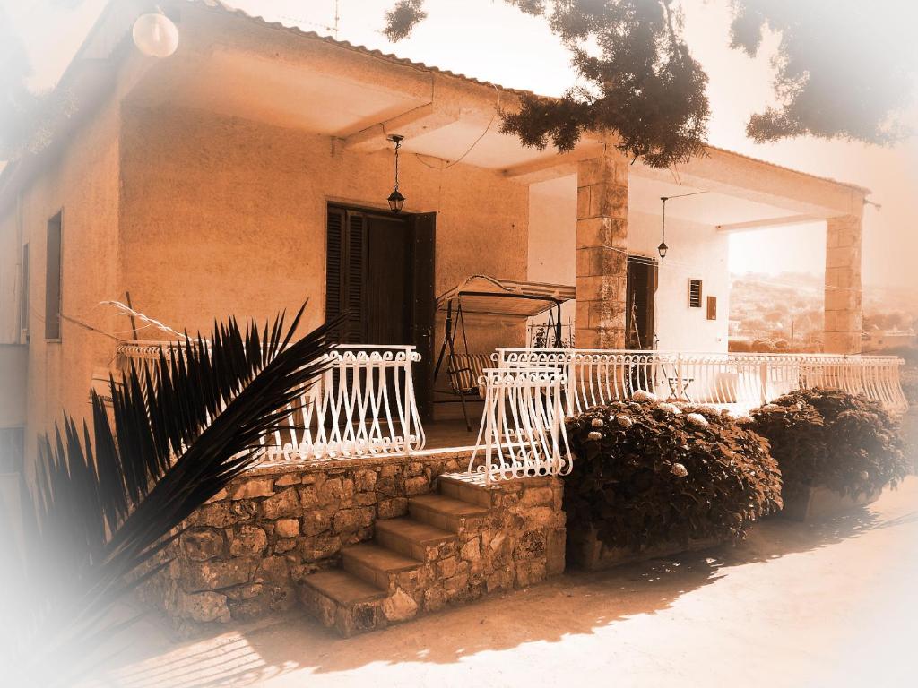 una casa de ladrillo con barandilla blanca y escalera en Villa Olimpo B&B, en Fasano