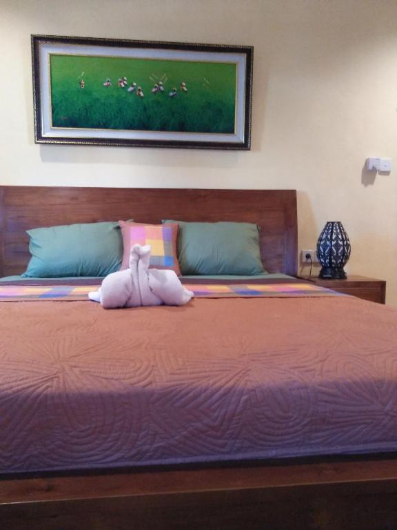een slaapkamer met een bed met een knuffeldier erop bij Wirya House in Ubud