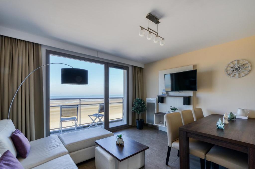 a living room with a room with a view of the ocean at Evancy Etoile de Mer in Bray-Dunes