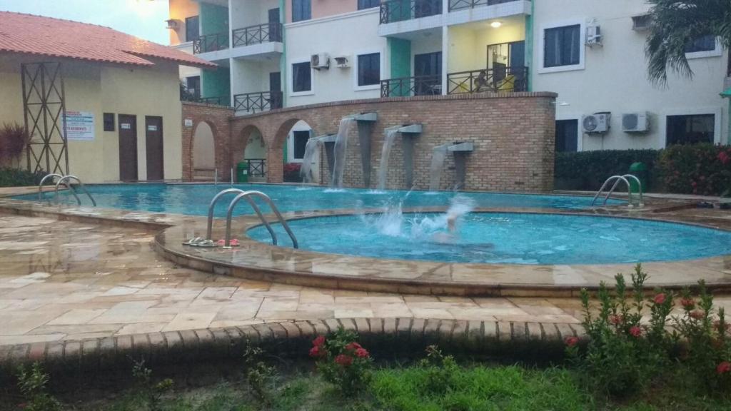 une piscine avec une fontaine au milieu d'un bâtiment dans l'établissement FLAT VILA DO MAR, à Aquiraz
