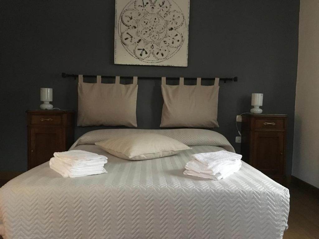 1 dormitorio con 1 cama con sábanas y almohadas blancas en BB Andre' en Vara Superiore