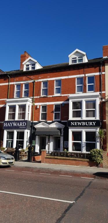 a large brick building on a street with a car at Hayward Hotel in Blackpool