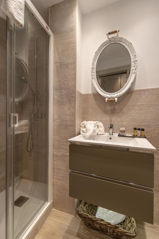 a bathroom with a sink and a shower and a mirror at Hostal Boutique Plaza Cantarero in Nerja