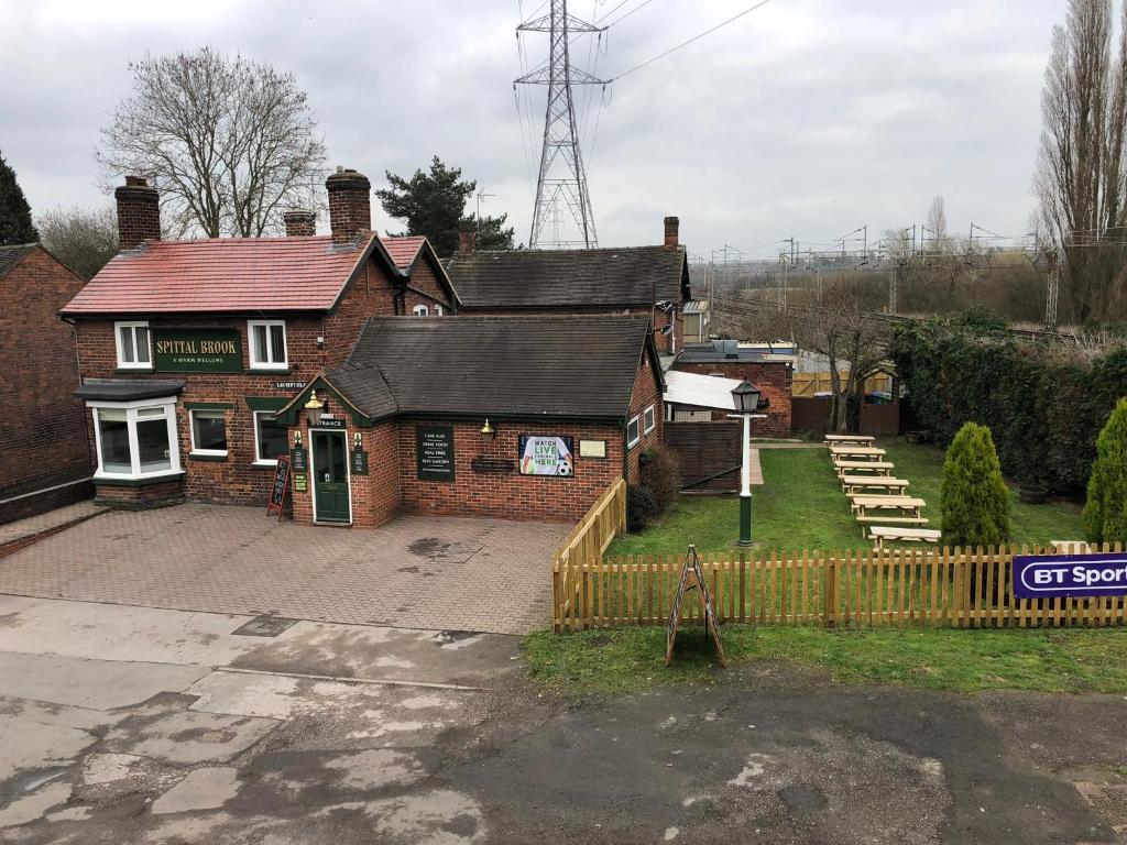 a brick house with a fence in front of it at SPITTAL BROOK in Stafford