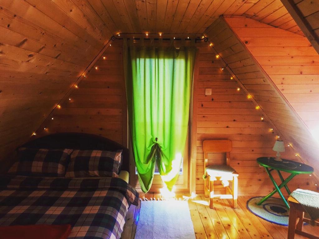 um quarto com uma cortina verde num sótão em Brvnara Borovik em Cetinje