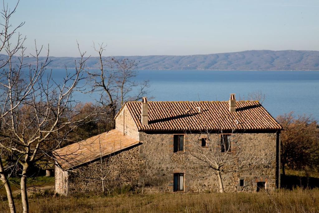 an old stone building with a lake in the background at Meridiano 12 in Bolsena