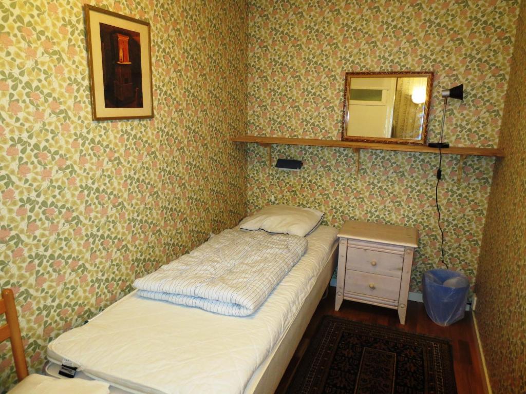 ein kleines Schlafzimmer mit einem Bett und einem Spiegel in der Unterkunft Hostel Bed & Breakfast in Stockholm