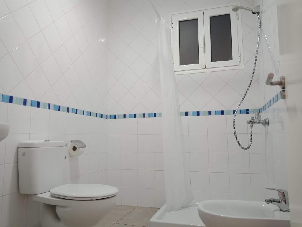 baño con aseo y lavabo y ventana en Columbus Apartments Co-Living, en Las Palmas de Gran Canaria