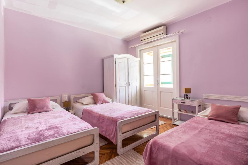 een kamer met 2 bedden met roze lakens en een raam bij Sunny Apartment Split in Split