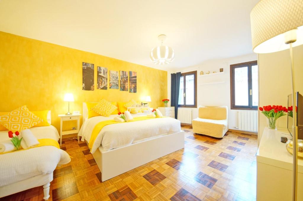 1 dormitorio con 2 camas y sofá en Calle dei Fabbri Apartment, en Venecia