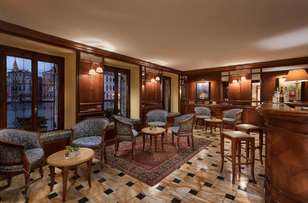a bar with chairs and tables in a room at Sina Palazzo Sant'Angelo in Venice