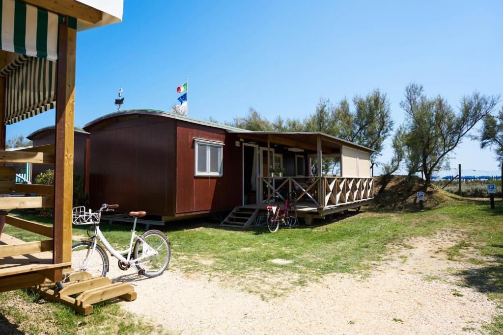 a house with a bike parked in front of it at Camping Lido in Bibione