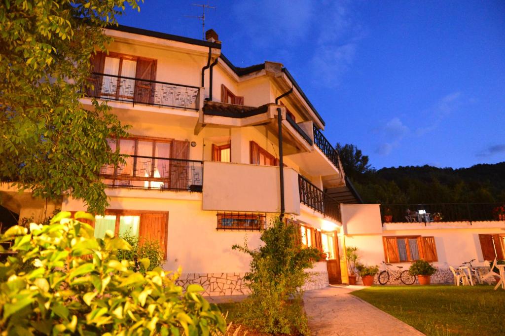 ein großes weißes Gebäude mit einer Veranda und einem Balkon in der Unterkunft Hotel Villa Stella in Cascia