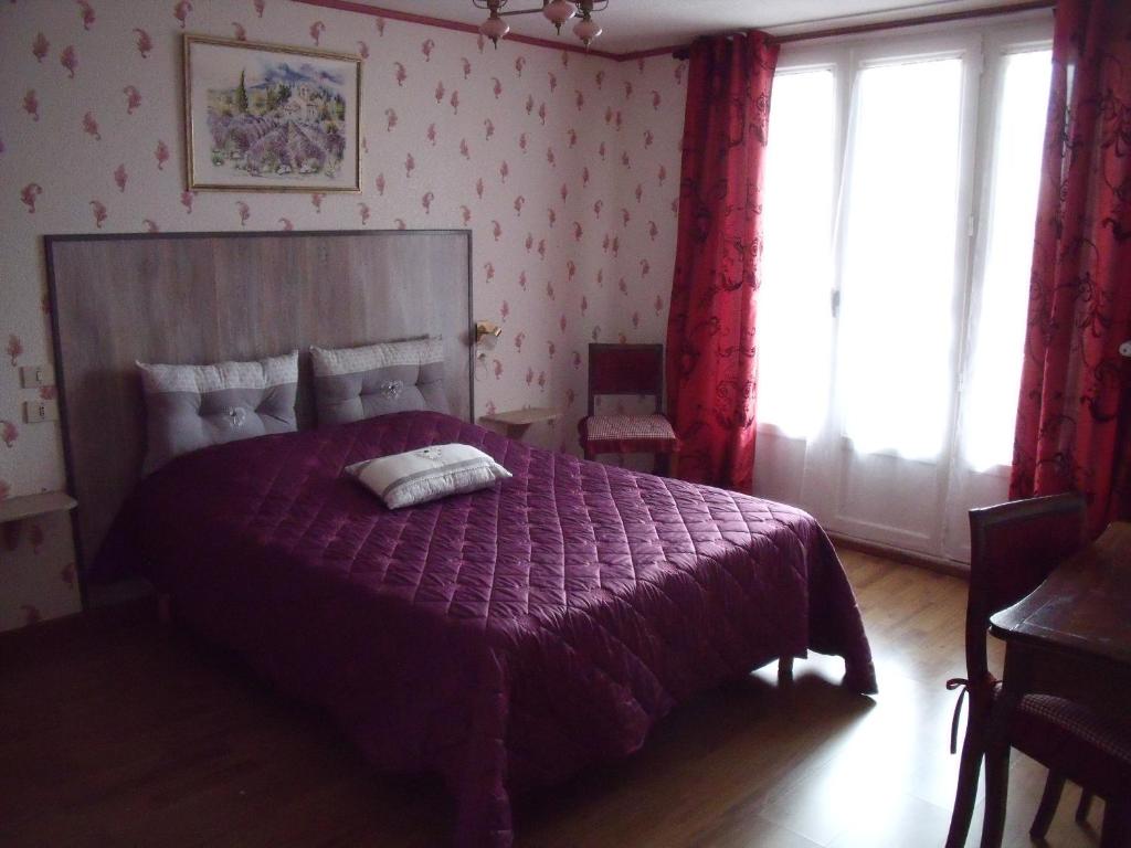 a bedroom with a purple bed with a purple comforter at Maison De Vacances in Blondefontaine