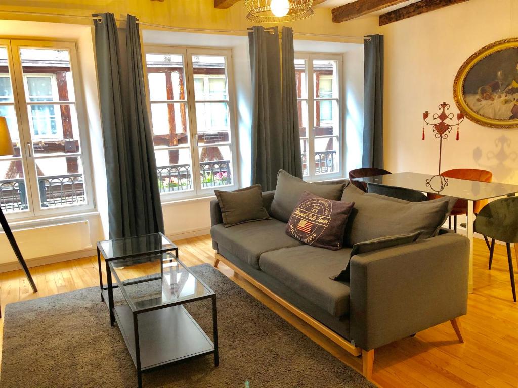 a living room filled with furniture and a large window at Carpe Diem Home - Au pied de la Cathédrale in Strasbourg