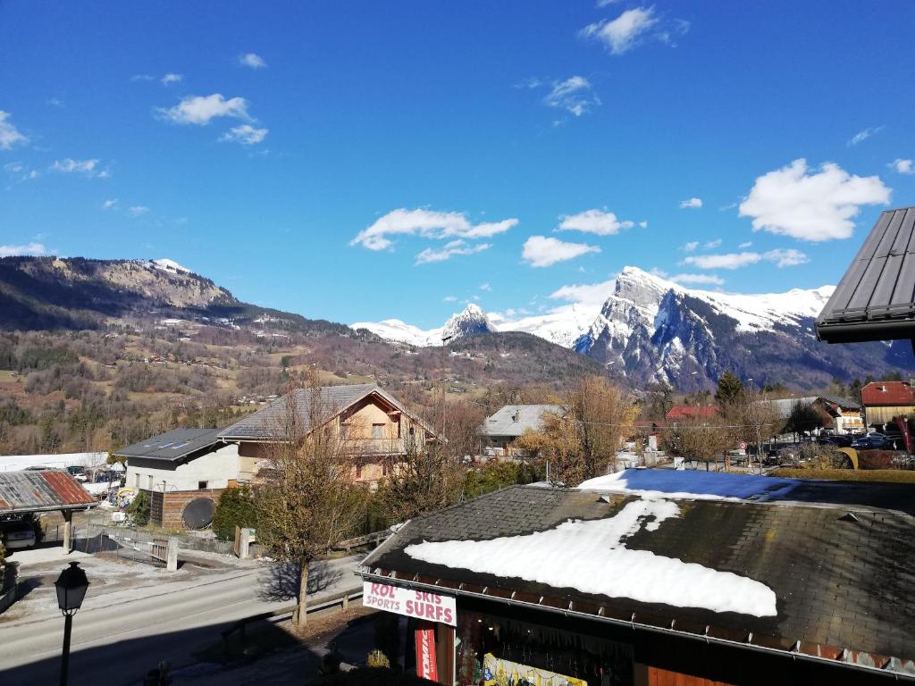 a town with snow covered mountains in the background at 40 Edelweiss des neiges in Morillon