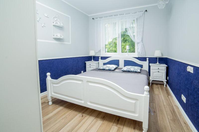 białe łóżko w niebiesko-białej sypialni w obiekcie Apartament Gdańska w Bydgoszczy
