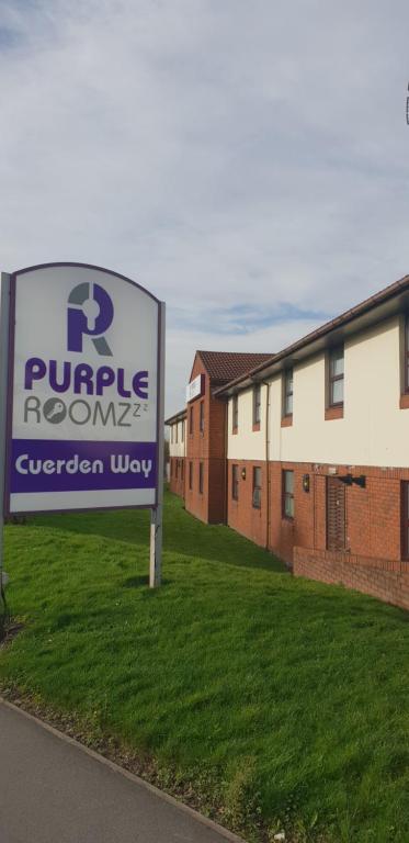 Purple Roomz Preston South في بريستون: علامة لغرفة أرجوانية أمام مبنى