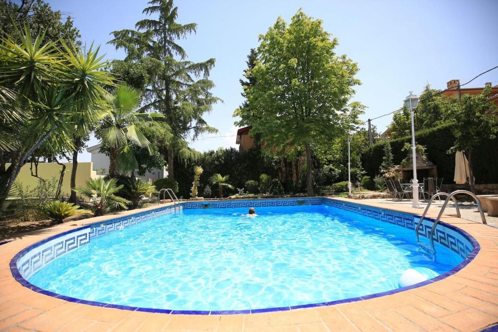 una grande piscina con una persona in acqua di El Pino Cajar Granada a Cájar