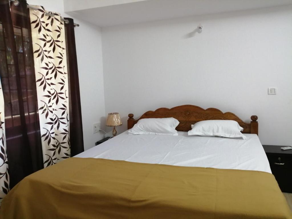 a bedroom with a large bed with white sheets at Apricot BH6 in Marmagao
