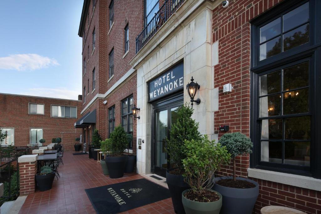 a brick building with a sign for a hotel room at Hotel Weyanoke in Farmville