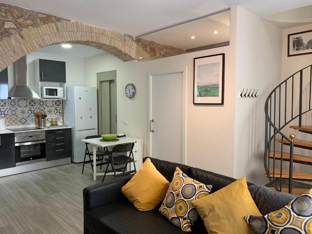ein Wohnzimmer mit einem Sofa und einer Küche in der Unterkunft Casa de piedra adaptada en LEscala in L'Escala