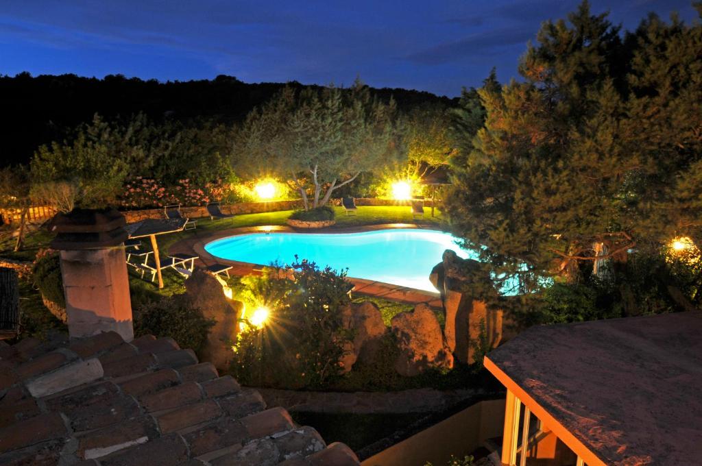 una piscina en un patio por la noche en Hotel Il Piccolo Golf en Porto Cervo