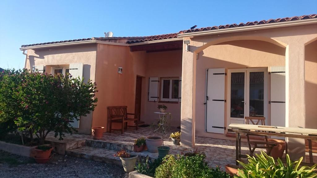 Cette petite maison dispose d'une terrasse et d'une table. dans l'établissement Joli villa que du bonheur, à Calenzana