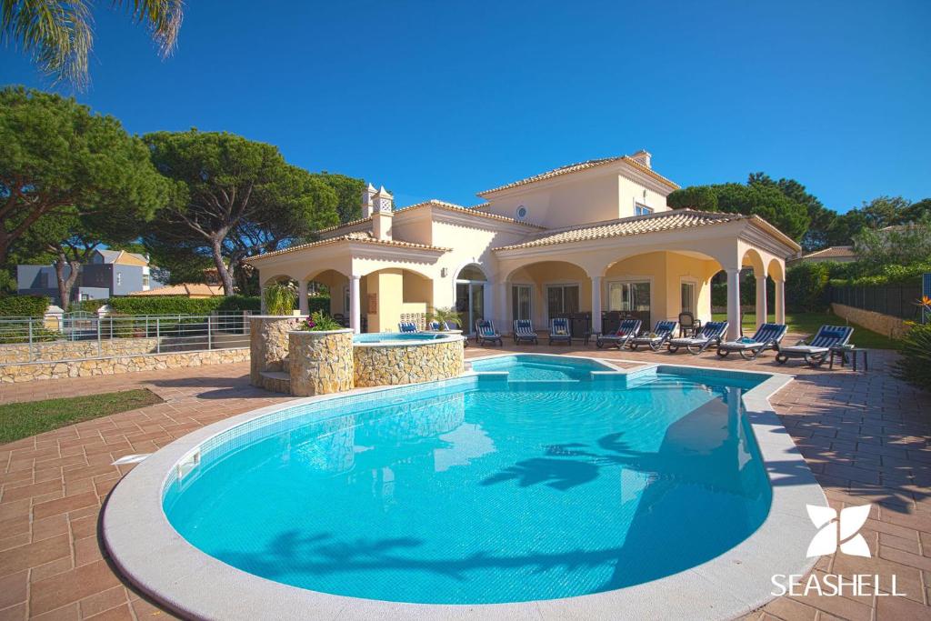 a large swimming pool in front of a house at Villa Hera in Vilamoura