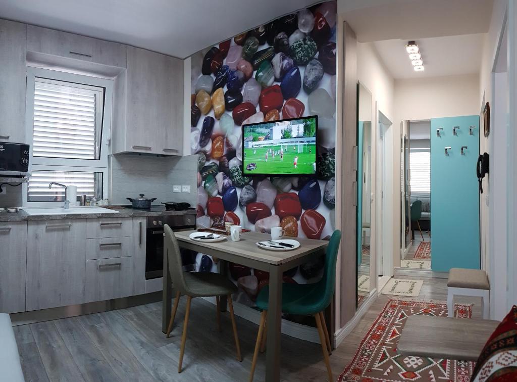 kuchnia ze stołem i telewizorem na ścianie w obiekcie Absolute Blloku Apartment w Tiranie