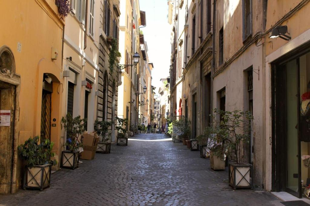 eine Gasse mit Gebäuden und Topfpflanzen auf einer Straße in der Unterkunft Marina in Rom