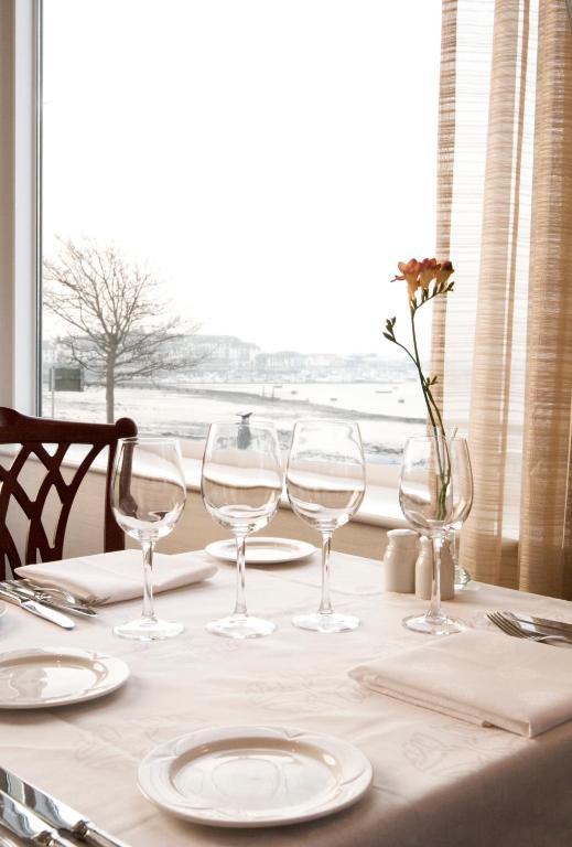a table with wine glasses and plates and a window at Grand Hotel in Malahide
