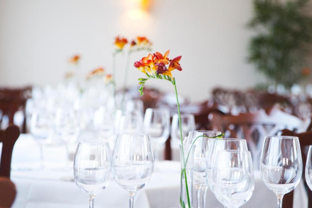 a table with wine glasses and a flower in a vase at Grand Hotel in Malahide