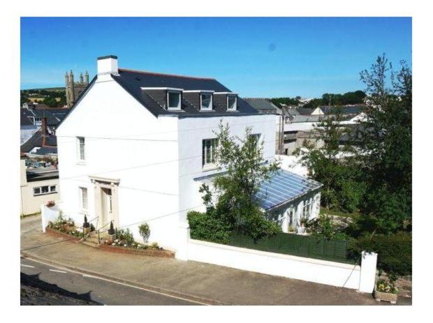 una casa blanca al lado de una calle en The Chantry en Callington