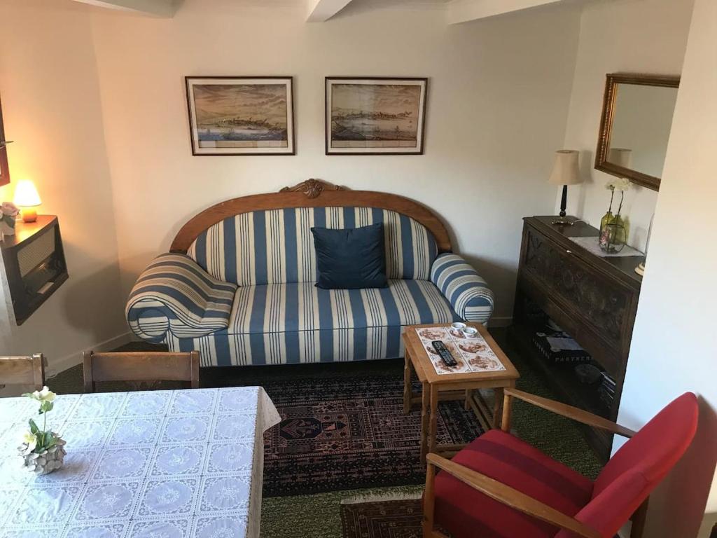 a living room with a couch and a table at Cosy old house Vágar next to Mykines in Sørvágur