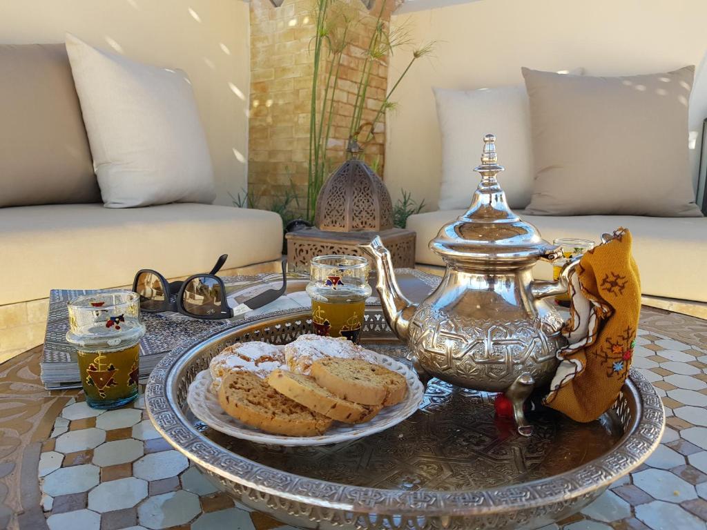a coffee table with a tea pot and a plate of food at Riad Fes Kettani in Fez