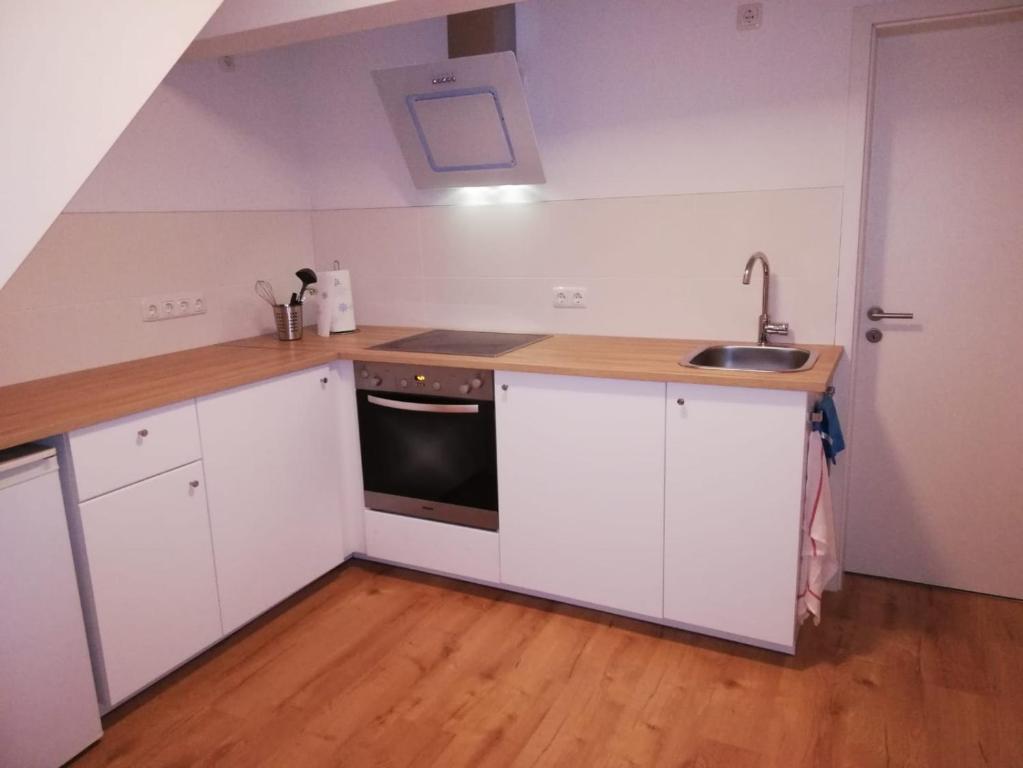 een keuken met witte kasten en een wastafel bij Apartement “Heckeresje“ in Pfungstadt