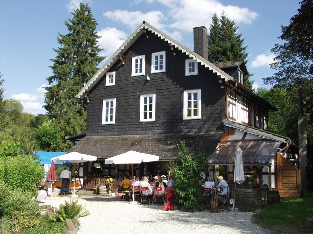 un grupo de personas sentadas fuera de un edificio en FeWo Landhaus Ederlust HeilungsRäume eV en Hatzfeld