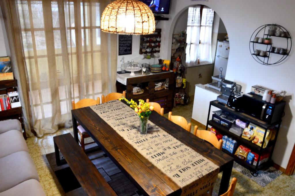 a dining room with a table and a kitchen at Mille Soli Bed and Breakfast in Buggerru