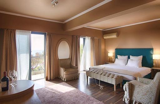 a bedroom with a large bed and a chair at Galaxy Hotel in Athens