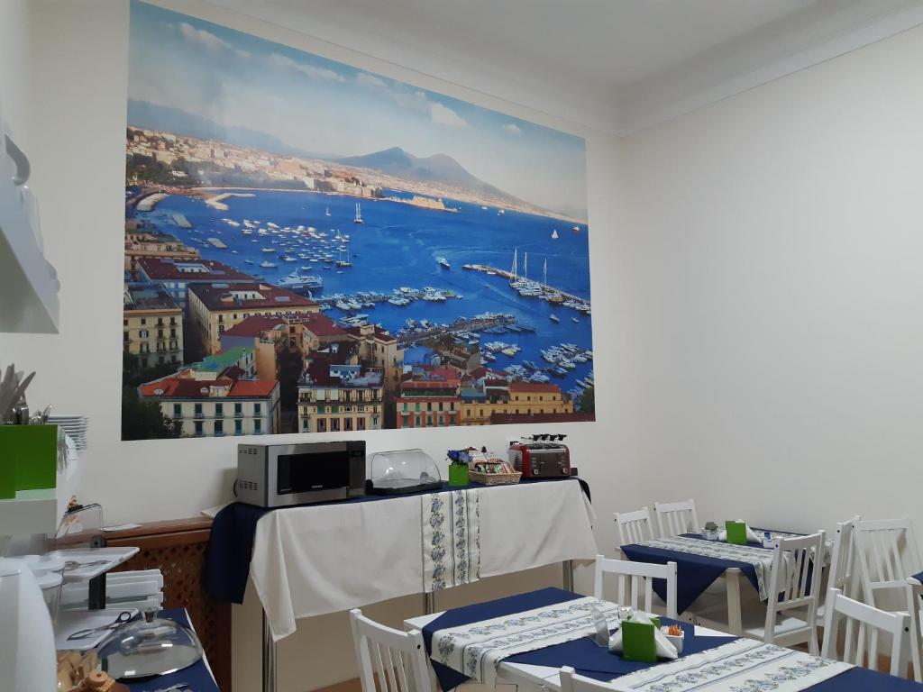 un dipinto di una città sulle pareti di un ristorante di B&B Foria 210 a Napoli