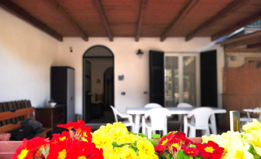 Cette chambre comprend une table, des chaises et des fleurs. dans l'établissement Come a casa, à Deiva Marina