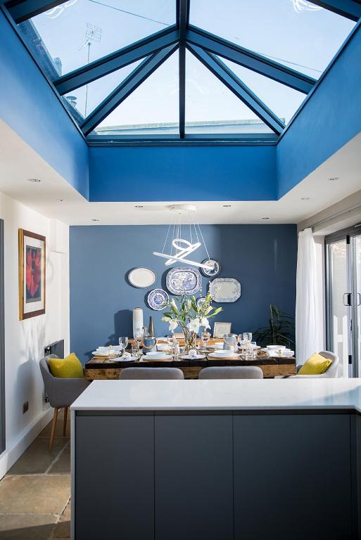 a dining room with a blue ceiling and a dining table at The Cottage and The Nook in Gretton