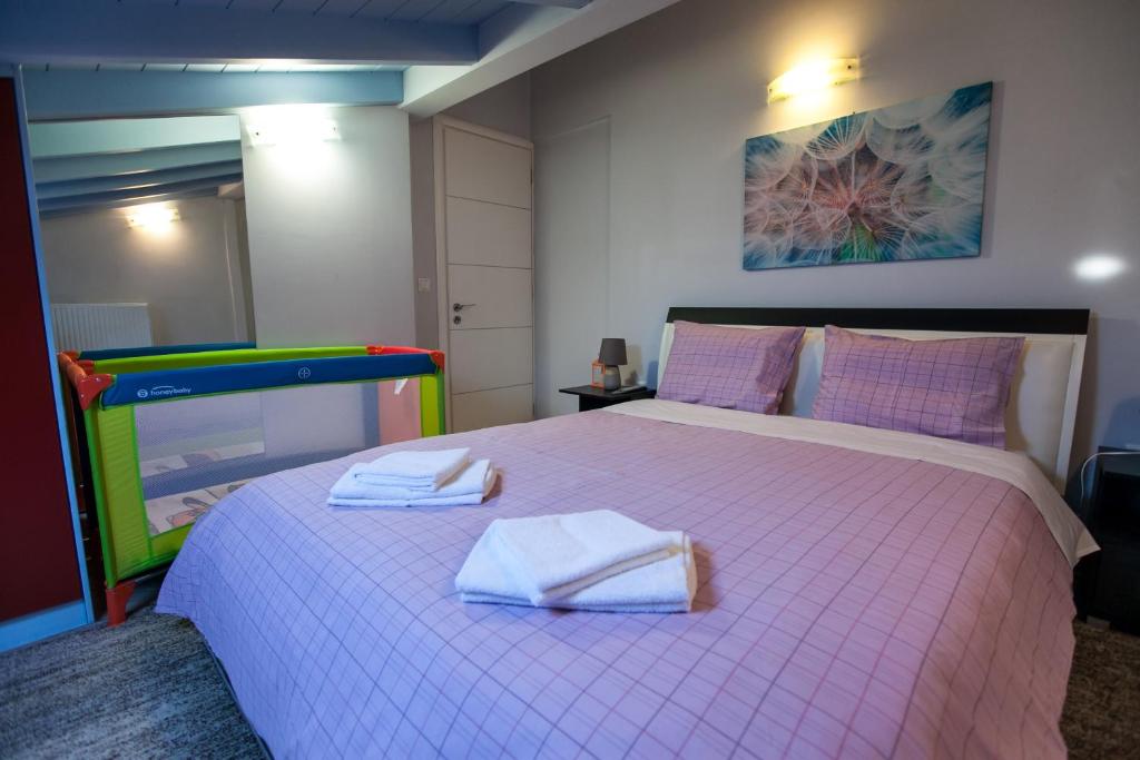 Un dormitorio con una cama rosa con toallas. en Blue Sky, en Nauplia