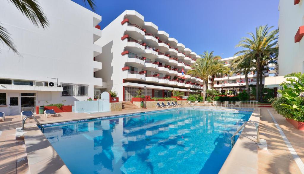 a swimming pool in front of a building at Apartamentos Lido in Ibiza Town