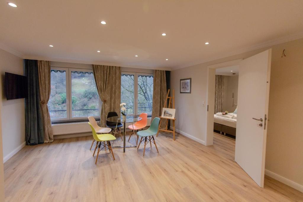 uma sala de estar com uma mesa e cadeiras e um quarto em Reichel-Appartements em Baden-Baden