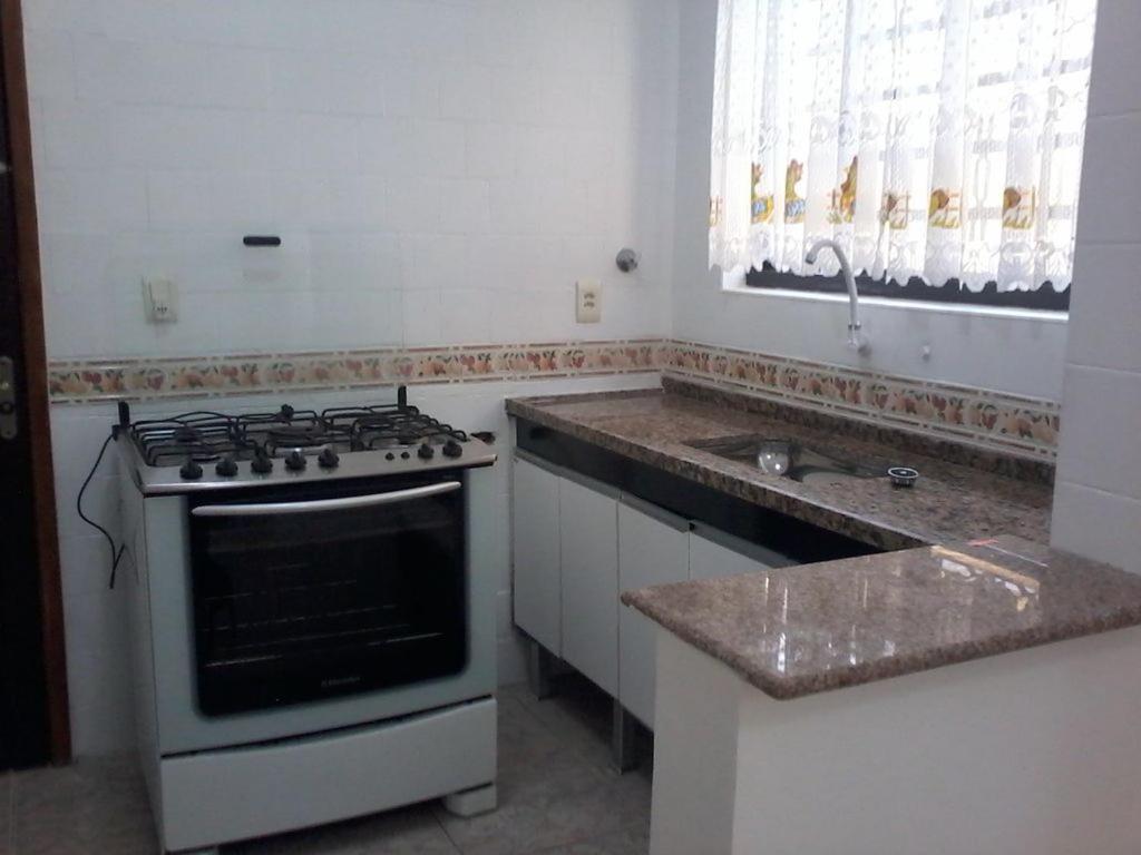 a kitchen with a stove and a sink at Casa do Sol in Praia Grande