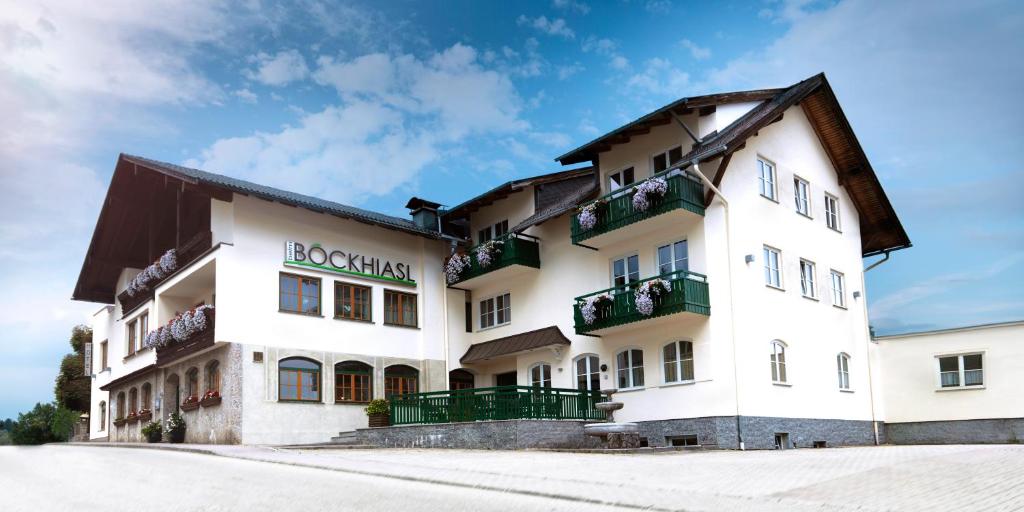 ein großes weißes Gebäude mit Balkon auf einer Straße in der Unterkunft Hotel-Gasthof Beim Böckhiasl in Neukirchen an der Vöckla