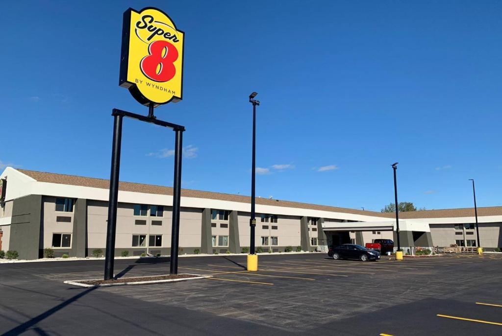 a building with a sign in front of a parking lot at Super 8 by Wyndham South Holland in South Holland