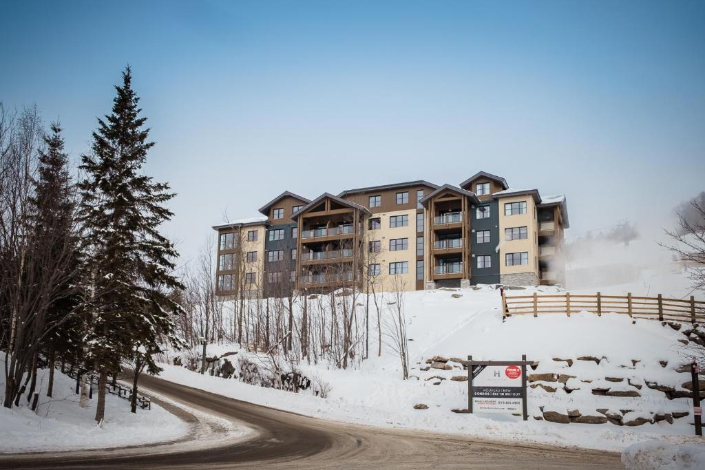 a road in front of a building in the snow at Tremblant Prestige - Horizon 1-104 in Mont-Tremblant